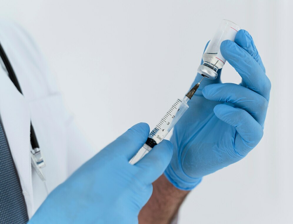 Медсестра в перчатках набирает в шприц лекарство перед постановкой укола